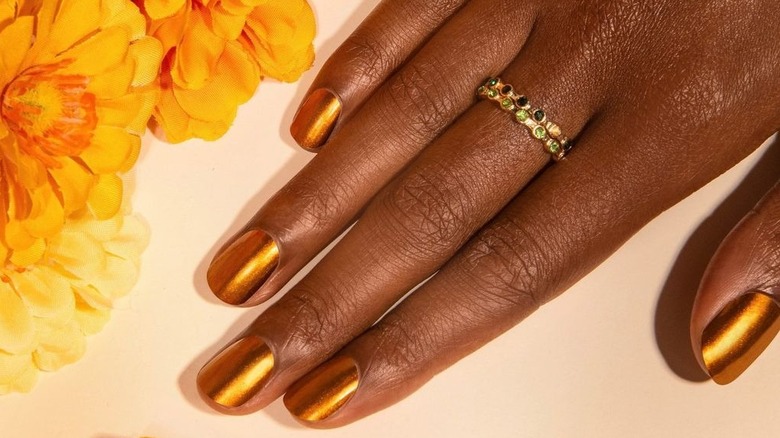 Gold nail polish on hand