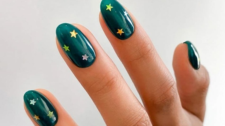 Star nail decals on green nails