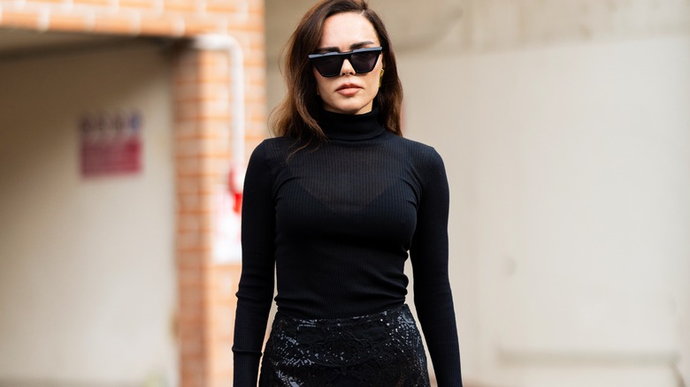 Woman wearing black turtleneck and sunglasses