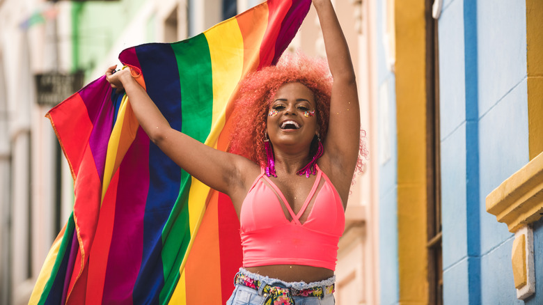 Woman holding Pride flag pink crop top