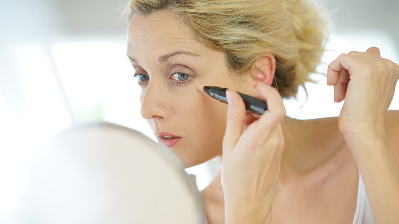 woman putting on concealer