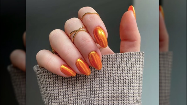 Short round manicure with orange chrome nail polish
