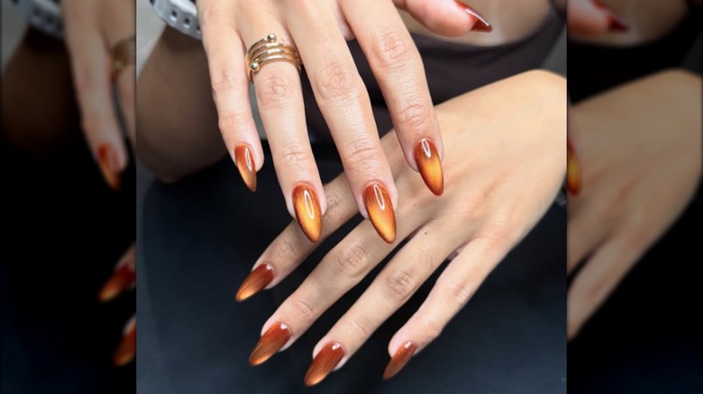Cat-eye manicure with orange and amber designs