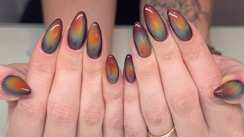 Hands with earth-toned aura nails.