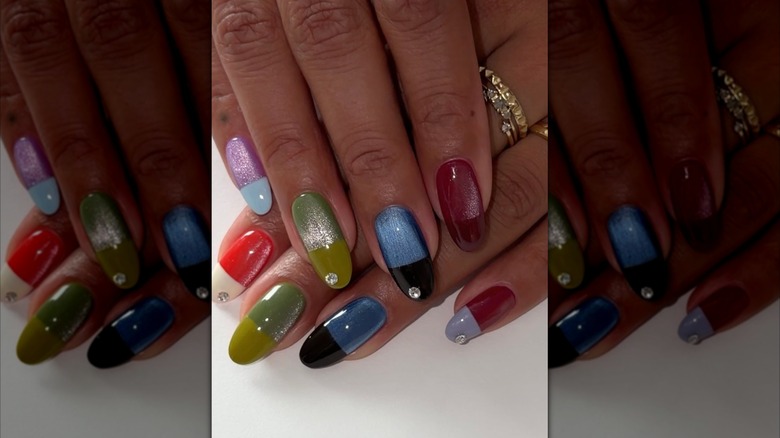 A hand with multi-colored nails.