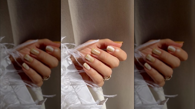 A hand with velvet butterscotch nails