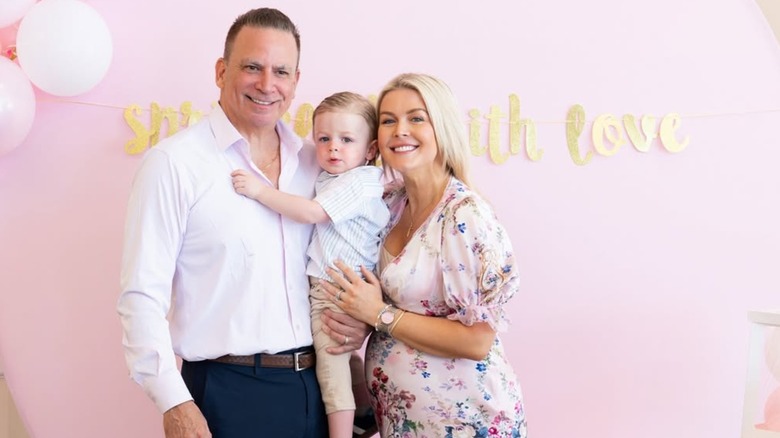 Karoline Leavitt and her older husband posing for a photo with their young son in between them