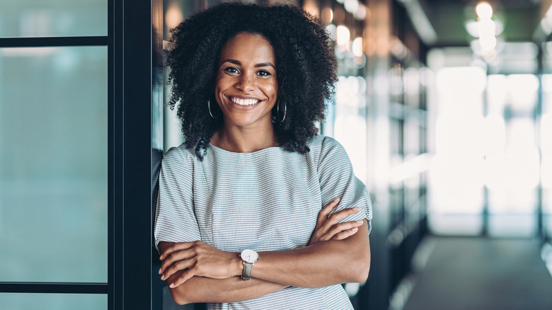 Woman smiling and leaning against door