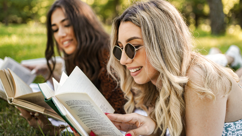 Female friends reading books outside