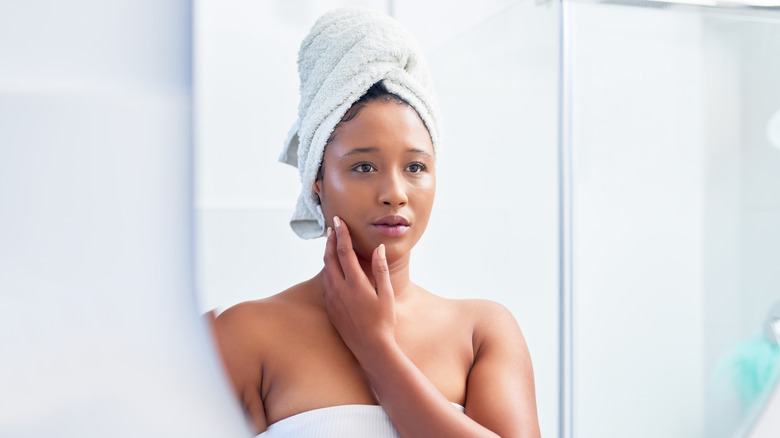 Woman looking in bathroom mirror