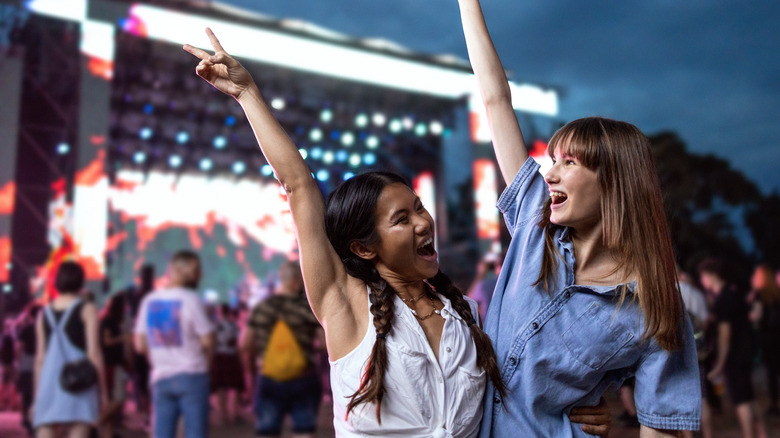 Two girls dancing at concert