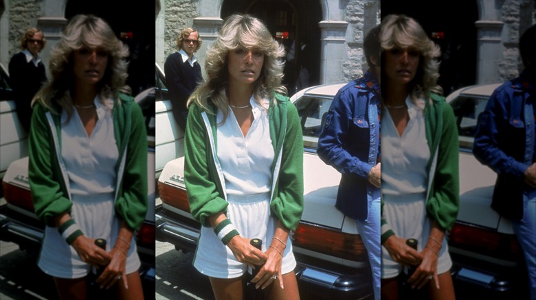 Farrah Fawcett wears a white tennis outfit and green jacket