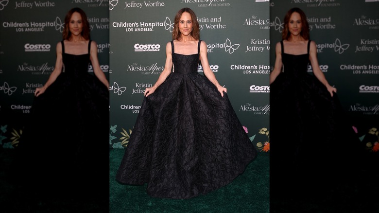 Nikki DeLoach wears a black floral-patterned dress