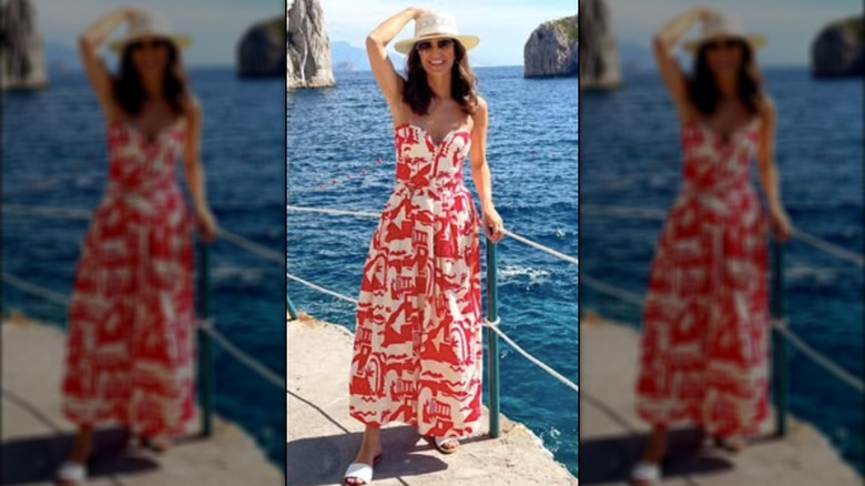 Kaitlan Collins posing for a photo in Italy in a sundress and hat