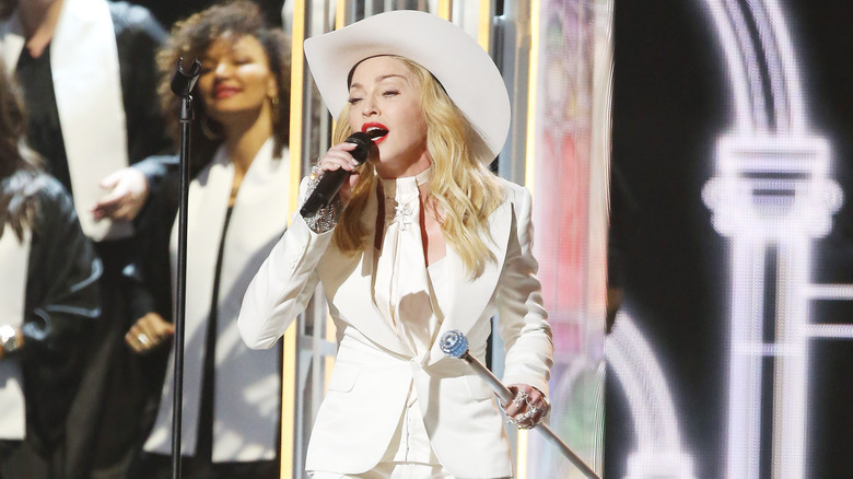 Madonna wears a white suit and cowboy hat to the 2014 Grammy Awards
