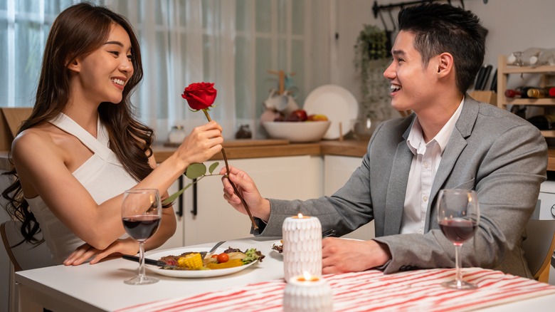 Man giving woman a rose