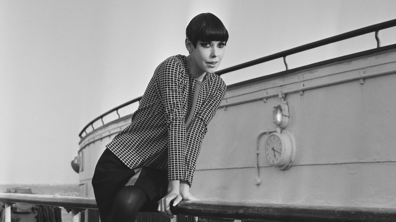 Fashion model Peggy Moffitt poses in the 1960s in front of a boat