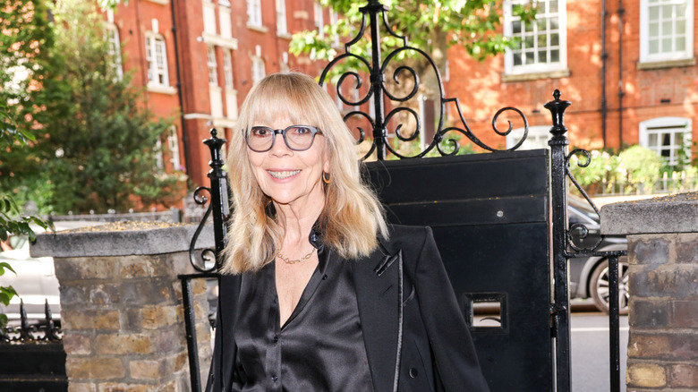 Penelope Tree attends a cocktail party wearing a black top, a black blazer and glasses