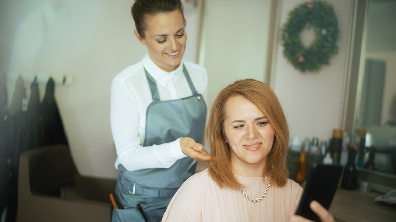 Woman getting a haircut pink sweater