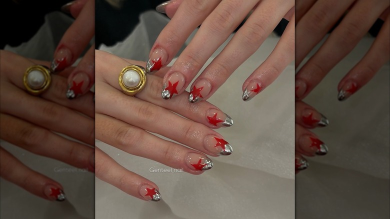 Nails with a chrome french tip and red stars.