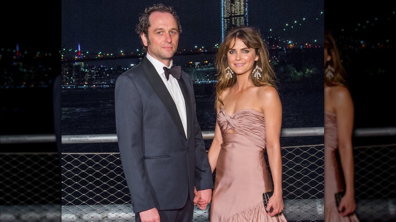 Matthew Rhys and Keri Russell hold hands while posing at an event in Brooklyn, New York.