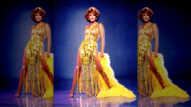 Ann-Margret wears a gold sequined dress and feathered cape designed by Bob Mackie in 1980
