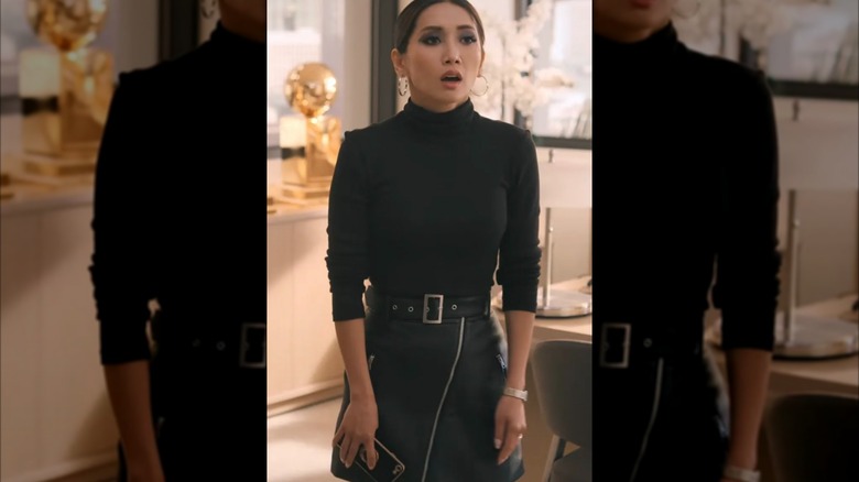 Brenda Song in a black turtleneck and black leather skirt