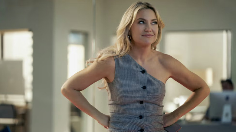 Kate Hudson in a one-shoulder gray top and a blowout