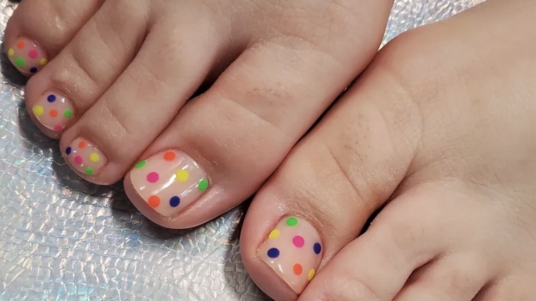Polka dot pedicure with pink, green, navy blue, orange, and yellow dots.