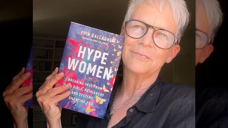 Jamie Lee Curtis holding the book Hype Women next to her face.