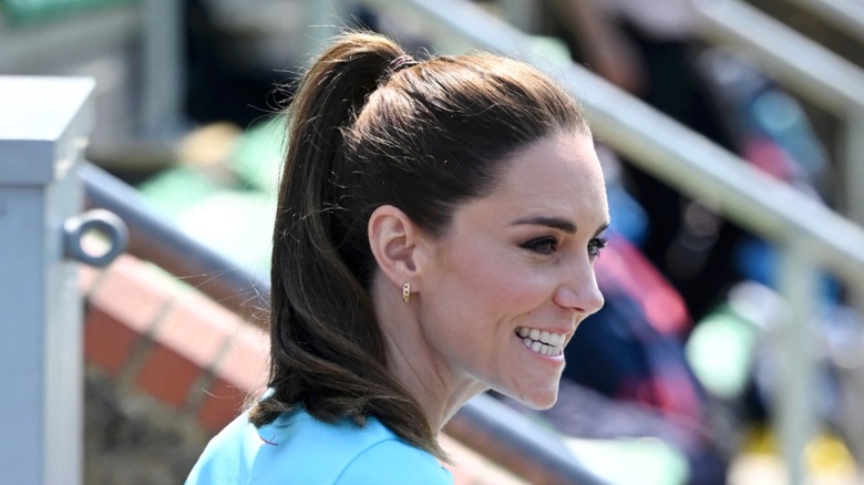 Kate Middleton wears a sky-blue t-shirt and a high ponytail while visiting Maidenhead Rugby Club in England in June 2023.
