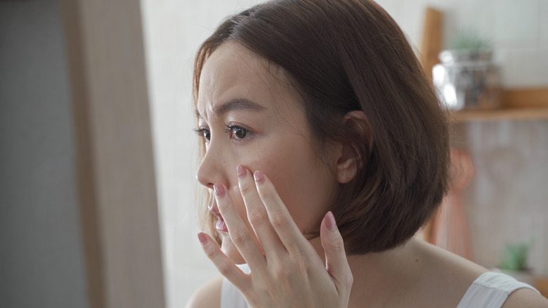 woman looking at skin