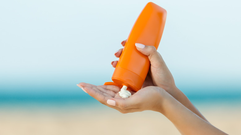 Person putting sunscreen on hand