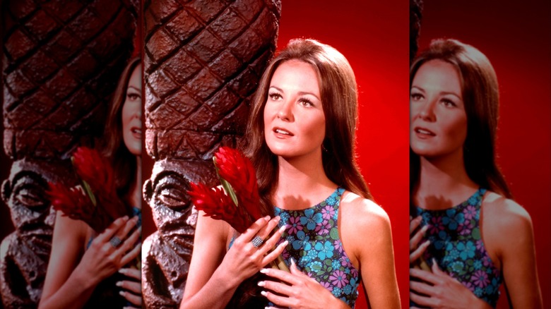 Shelley Fabares posing in a floral dress holding ginger flowers in a portrait circa 1965.