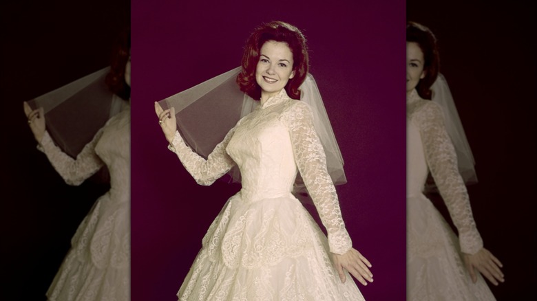 Shelley Fabares poses in a lacy wedding gown with a short veil for a 1965 portrait.