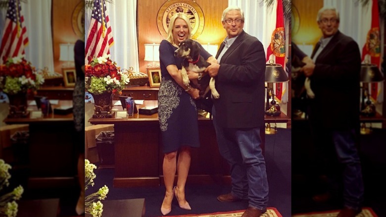 Pam Bondi holds a rescue dog in her Florida office