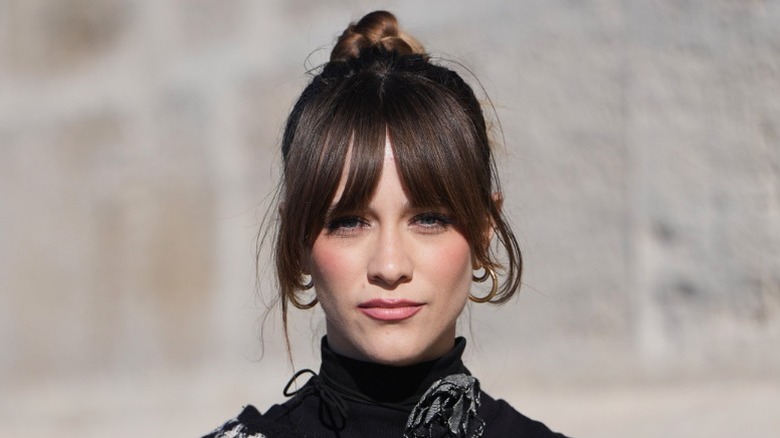 A woman wears an updo with curtain bangs