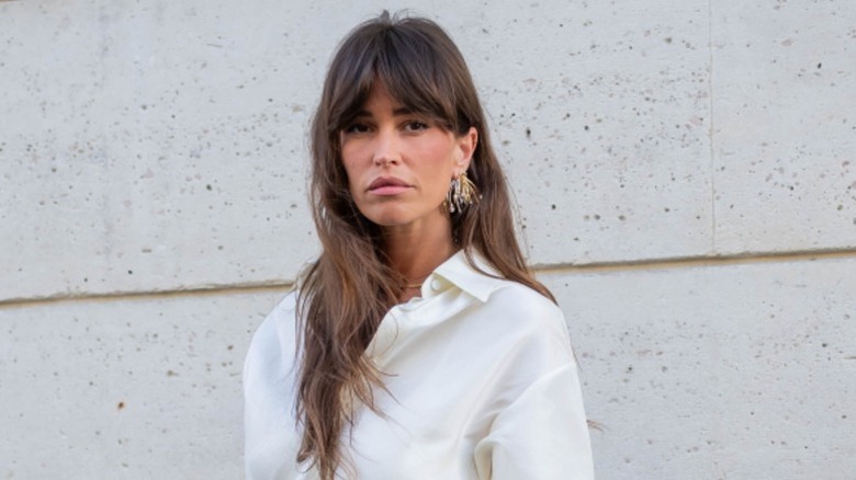 A woman on the street wears her hair long with long bangs