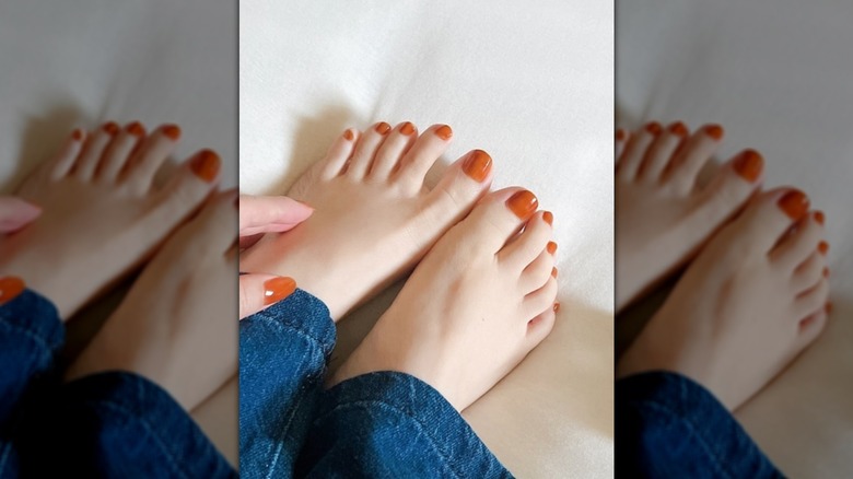 Close up to a burnt orange pedicure