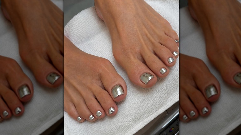 Two feet with silver chrome pedicure