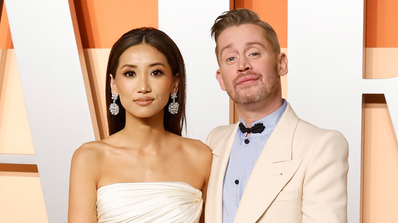 Brenda Song posing next to Macaulay Culkin at the Vanity Fair Oscar Afterparty