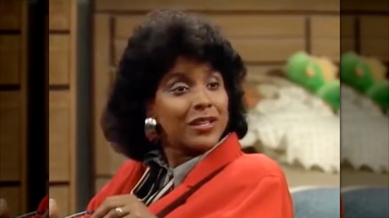Phylicia Rashad wearing silver hoop earrings and an orange blazer