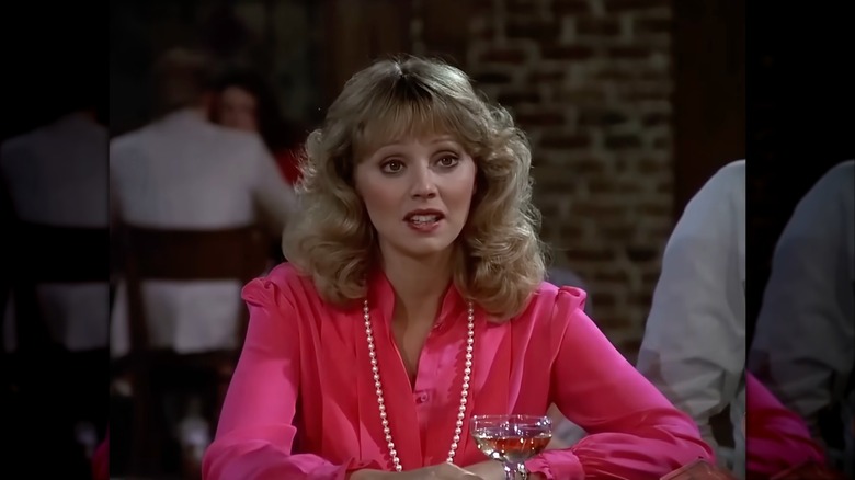 Shelley Long wearing a hot pink blouse and a long pearl necklace