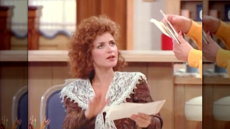 Annie Potts wearing a brown lace-trim blouse with curly red hair