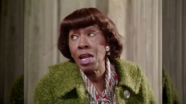 Helen Martin wearing a green coat and a patterned cream blouse