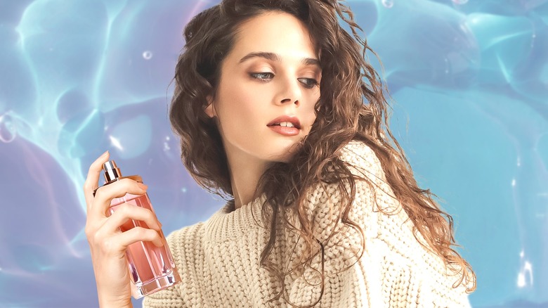 Woman spritzing herself with perfume