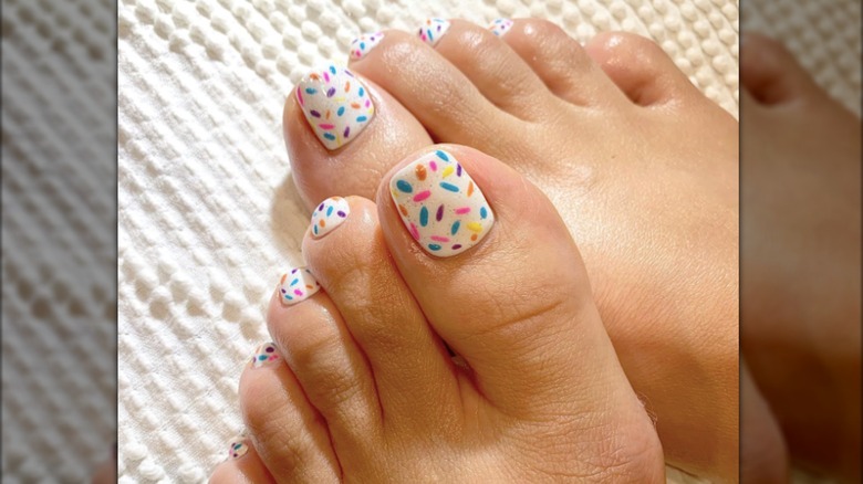 A pedicure with a multicolored confetti-like design