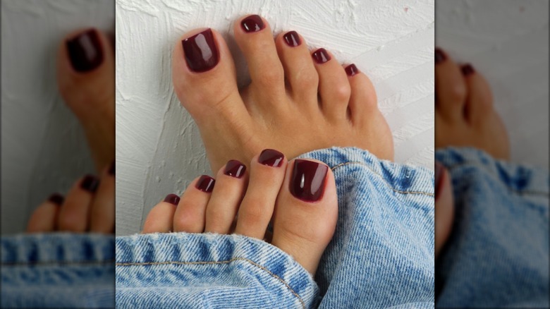 A pedicure with dark burgundy nail polish