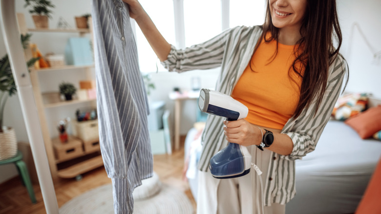 A woman steaming her shirt