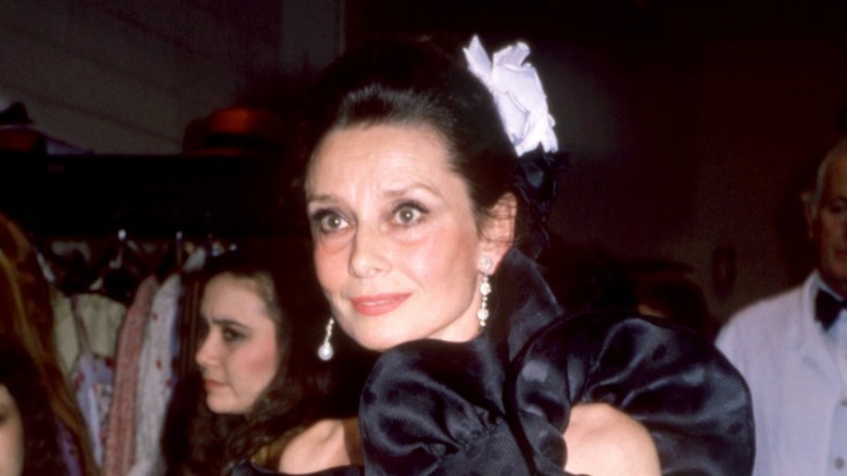 Audrey Hepburn with an updo and white flower in her hair